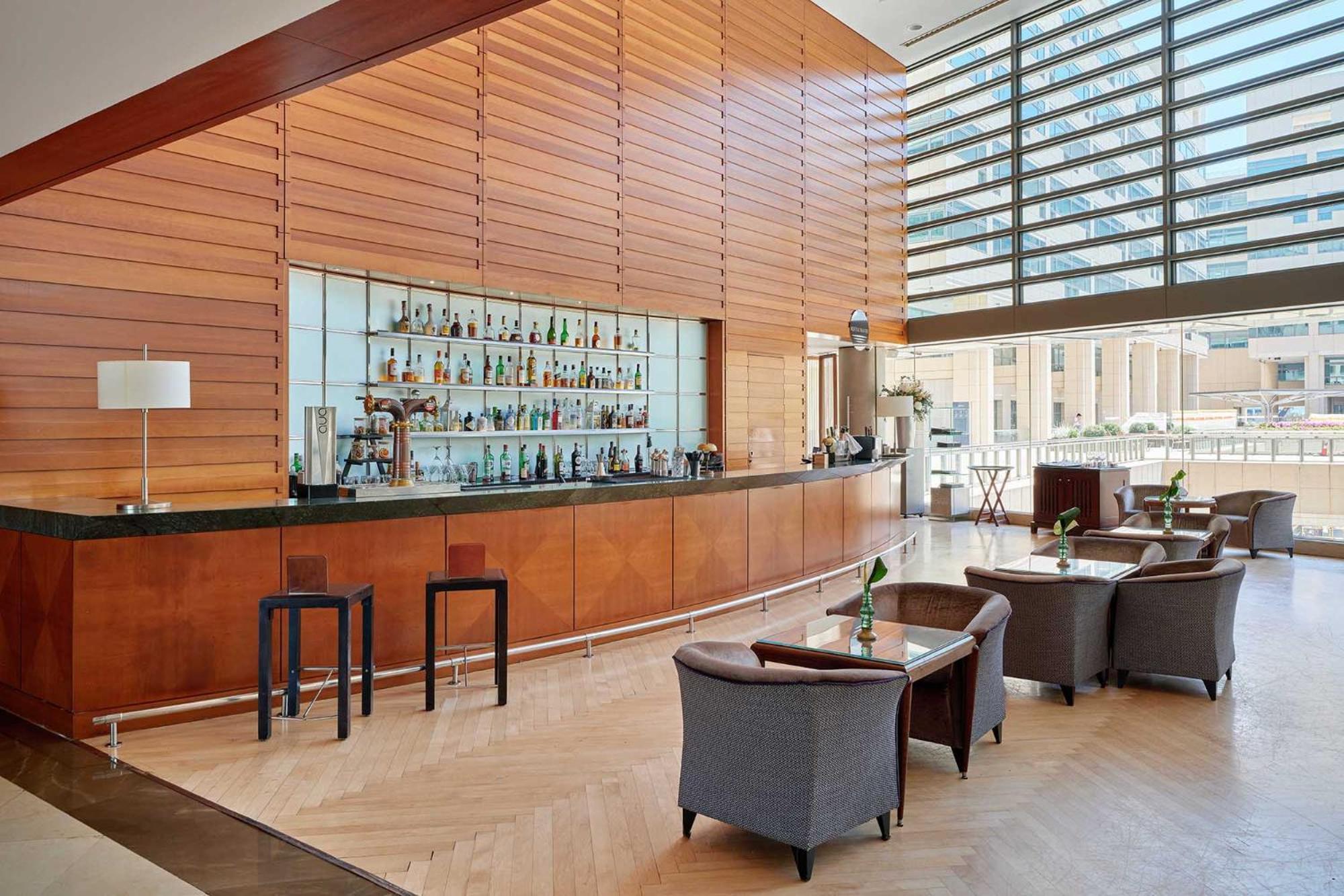 Eurostars Grand Marina Hotel Gl Barcelona Bagian luar foto The photo shows a modern bar area with a sleek, minimalist design. There is a long, polished bar countertop behind which various bottles of drinks are displayed. The walls feature wooden paneling that creates a warm ambiance, and large windows allow 